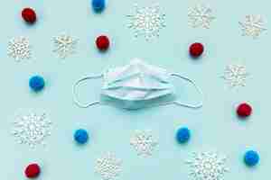 Free photo top view medical mask and decorative snowflakes