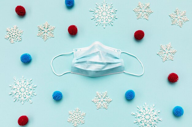 Top view medical mask and decorative snowflakes