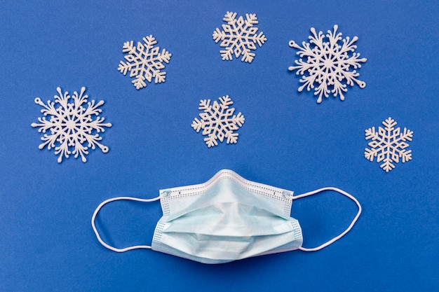 Top view medical mask and snowflakes