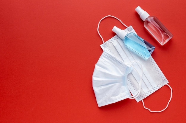 Top view of medical masks with hand sanitizer and copy space