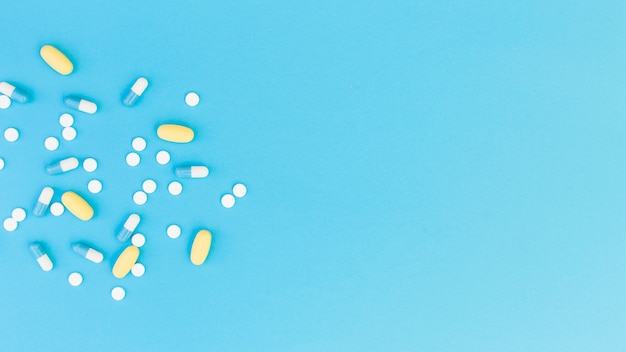 Вид сверху медицинских таблеток и капсул на синем фоне