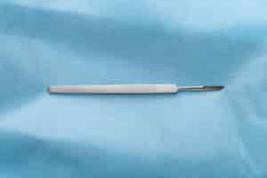 Free photo top view of medical scalpel on blue tissue