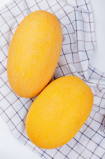 Top view of melons on plaid cloth and white background