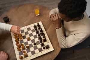 Free photo top view men playing chess indoors