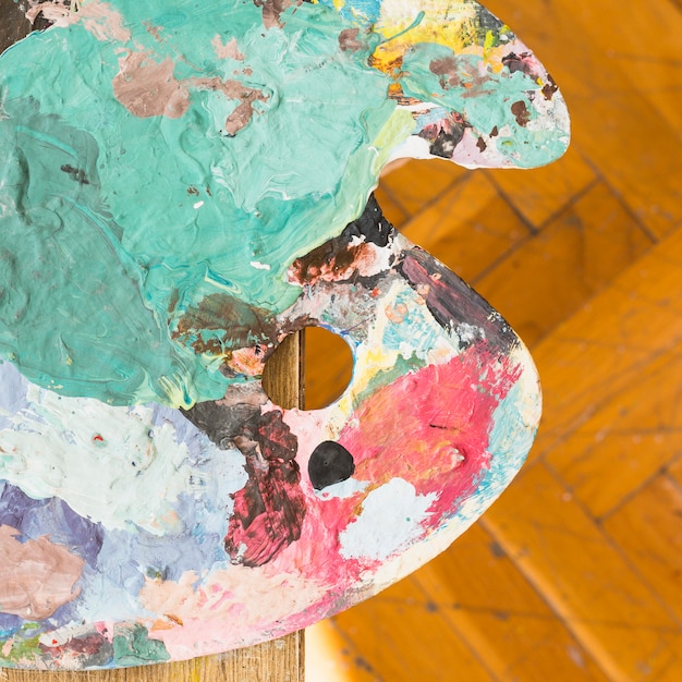 Free photo top view of messy oil paint wooden palette