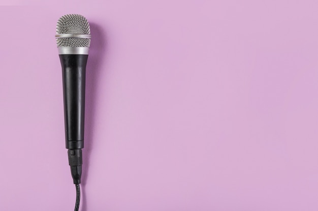 Top view of microphone on pink background