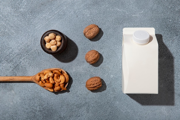 Free photo top view milk carton and nuts arrangement