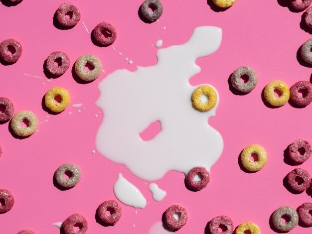 Top view milk and cereals on pink background