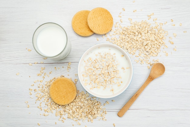 Бесплатное фото Вид сверху молоко с овсяной мукой вместе со стаканом молока и печеньем на белом, молочное молоко завтрак здоровье