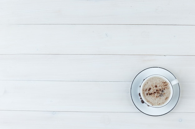 Вид сверху молочный кофе в чашке на деревянных фоне. горизонтальный