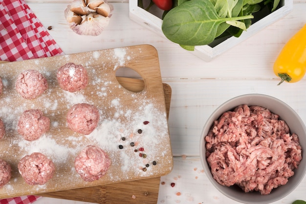 Top view minced meat and meatballs on wooden board