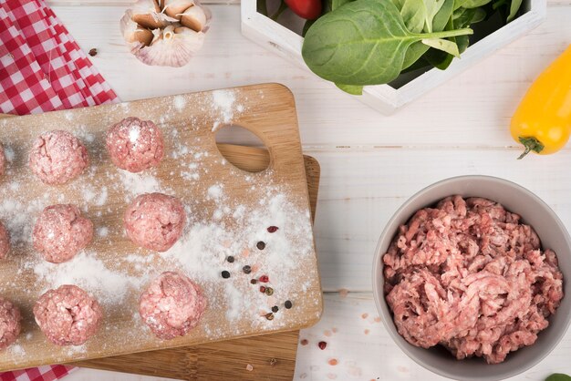 Top view minced meat and meatballs on wooden board