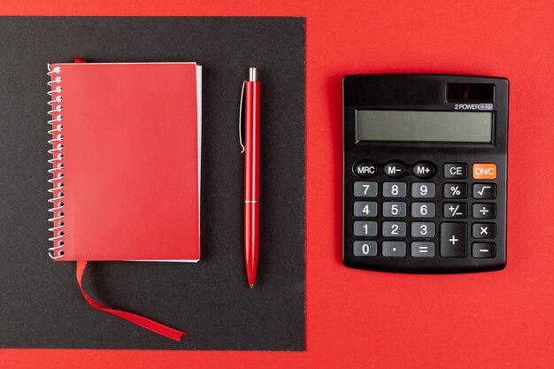 Top view mini calculator next to red notebook