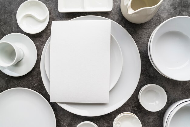 Top view of minimalist white plates with empty menu