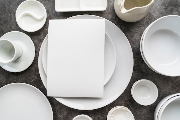 Top view of minimalist white plates with empty menu