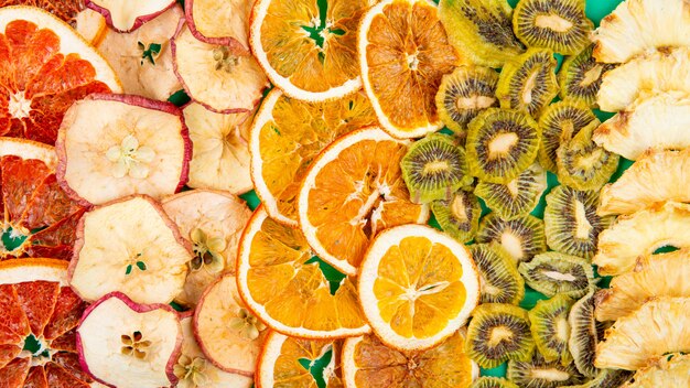 Top view of mix of dried fruits and citruses slices apple orange kiwi and pineapple background of dried fruits and citruses