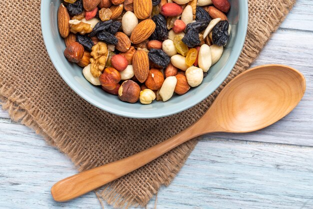 Top view of mix of nuts and dried fruits in a bowl on rustic