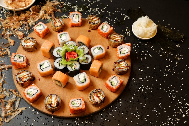 Top view mix of sushi and rolls with wasabi and ginger on a stand