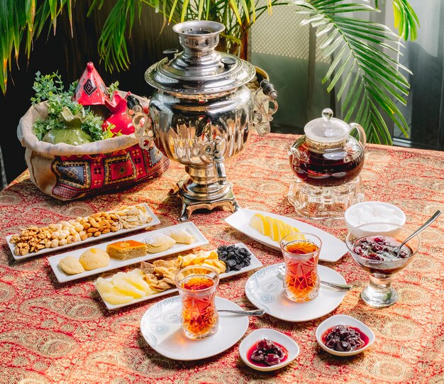 Top view mix tea set for two persons with a samovar teapot and sweets on the table