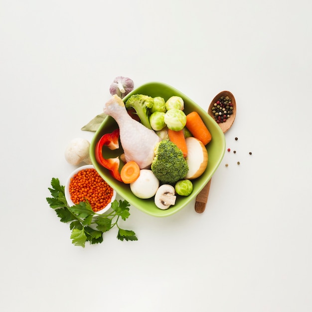 Top view mix of vegetables in bowl with chicken drumstick