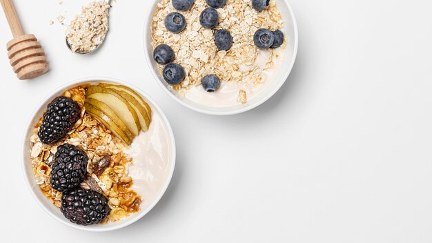 Top view mix of yogurt with oats and fruits in bowls with copy-space