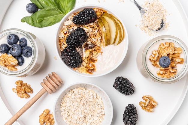 Top view mix of yogurt with oats, fruits and honey on plate