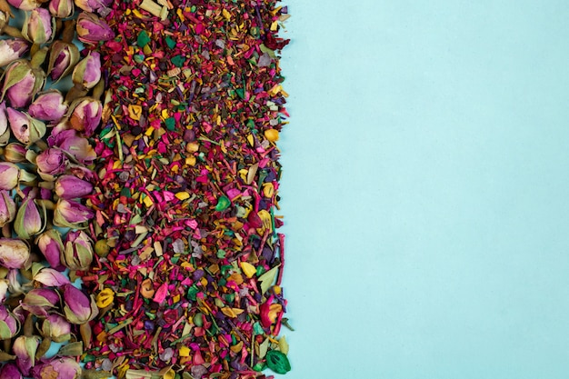 Free photo top view of mixed herbal tea blooms rose petals dried rose buds and herbs on blue