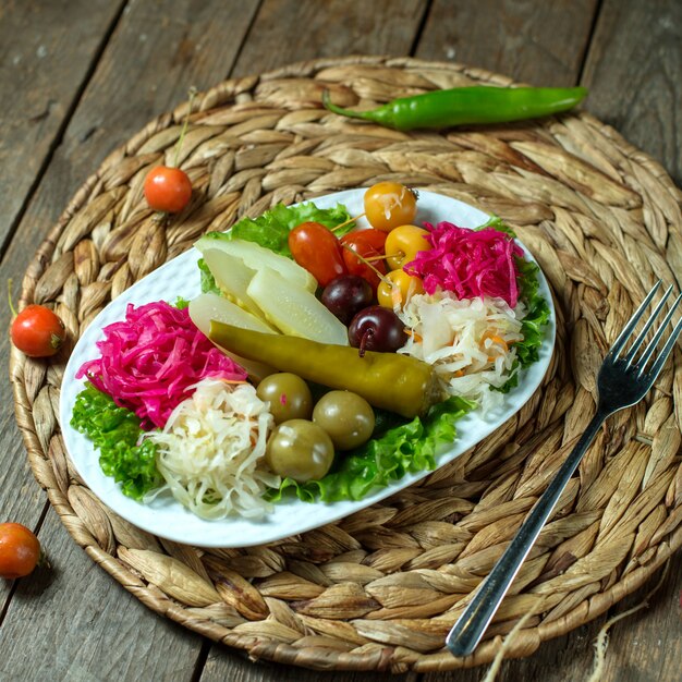 Top view of mixed pickles cabbage olives cucumbers and pepper on a platter