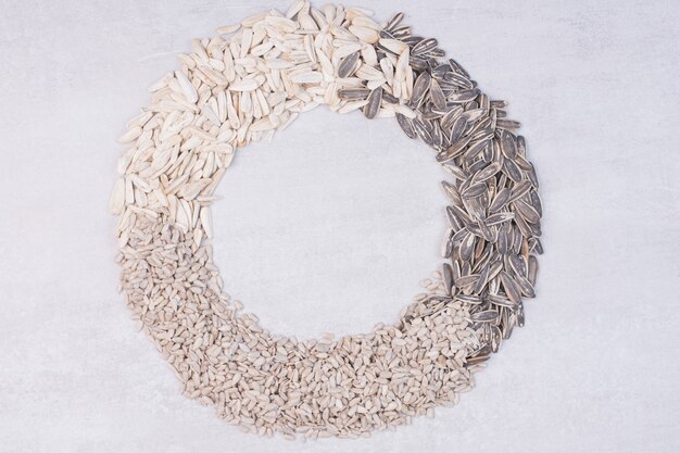 Top view of mixed sunflower seeds on white surface.