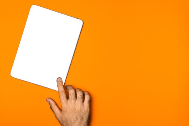 Вид сверху макет планшета с оранжевым фоном