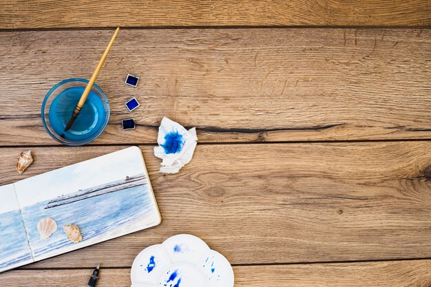 Top view of modern artist desk with watercolor equipment