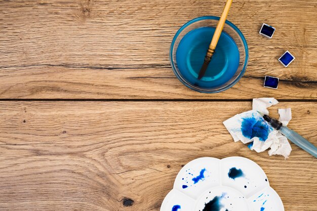 Top view of modern artist desk with watercolor equipment