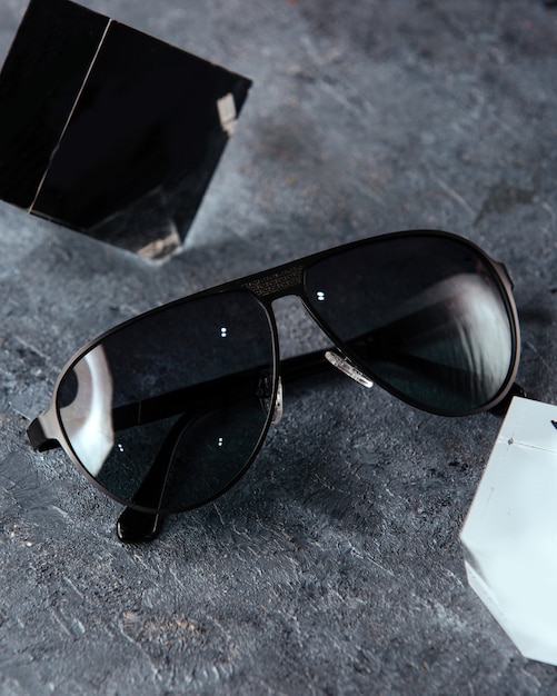 A top view modern black sunglasses on the grey background isolated vision spectacles elegance