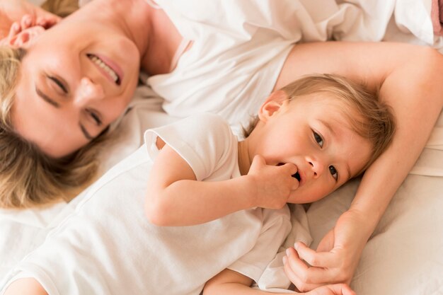 Top view mom and baby sitting in bed