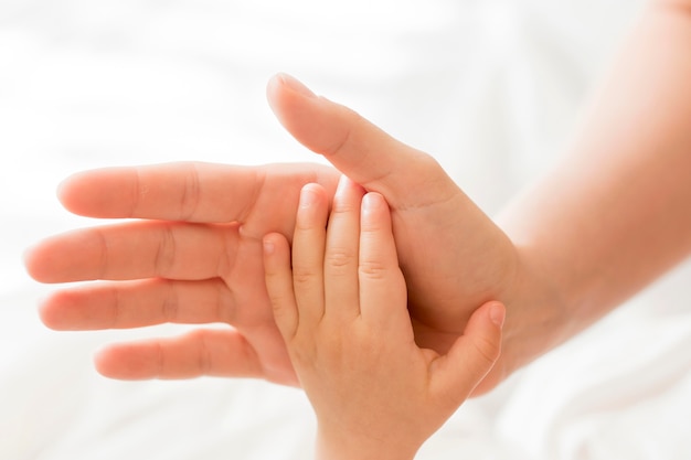 Top view mom holding baby's hand