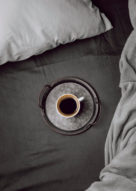 Vista dall'alto della tazza di caffè del mattino sul letto