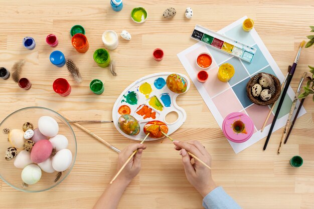 Top view mother and son painting easter eggs