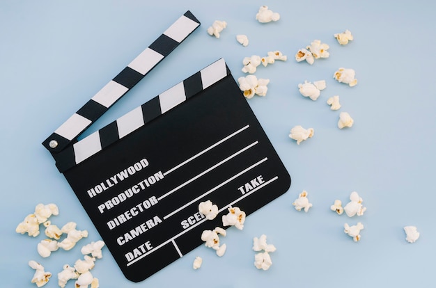 Top view movie clapperboard with popcorn