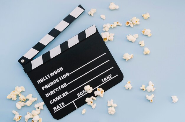 Top view movie clapperboard with popcorn