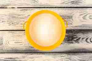 Free photo a top view much salt inside yellow round plate on the grey rustic wooden desk