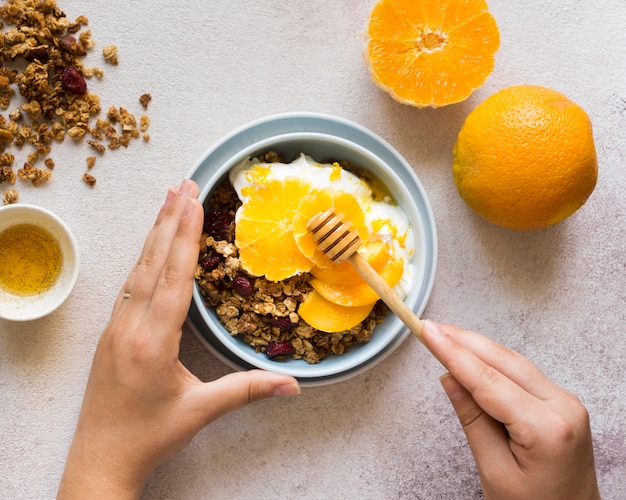 Top view of muesli with oranges in bowl