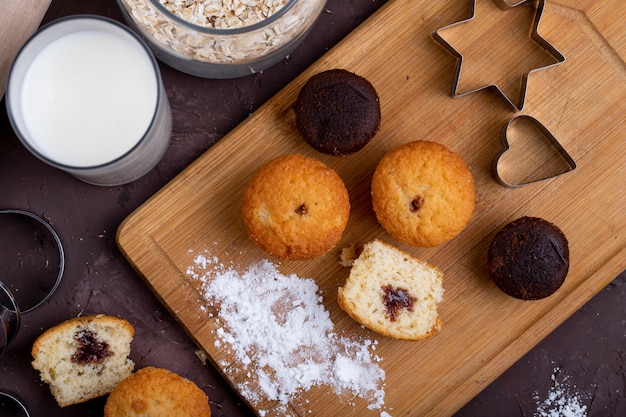 Top view of muffins with chocolate on a wooden cutting board