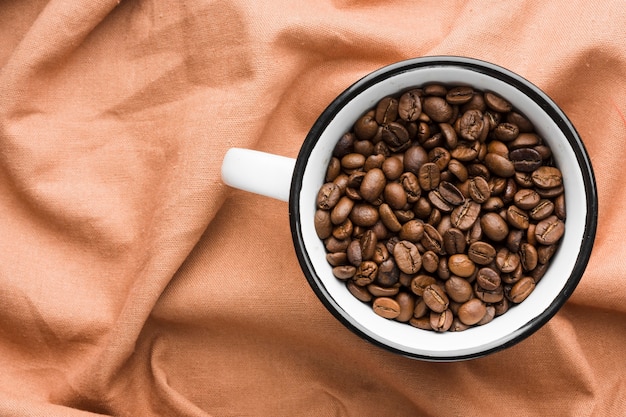 Top view mug with roasted coffee beans