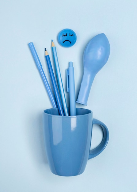 Top view of mug with sad face and balloon for blue monday