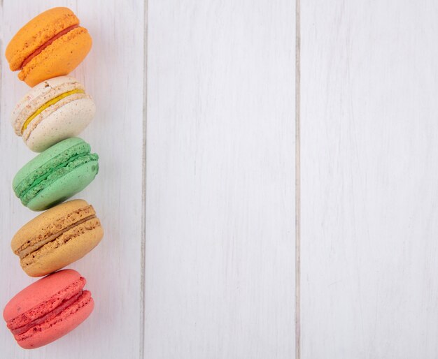 Top view of multi-colored macarons on a white surface