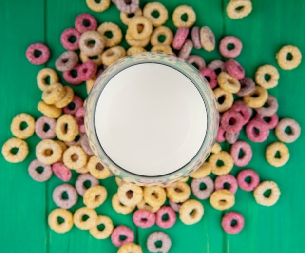 Free photo top view of multicolored cereals isolated on green surface