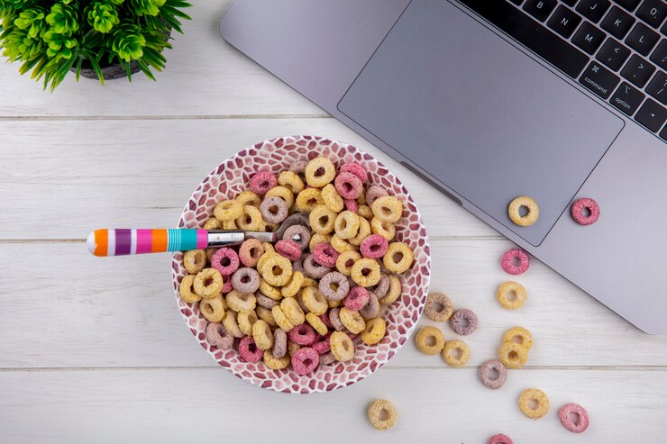 Free Photo top view of multicolored and healthy cereals on a bowl with colorful spoon on white surface