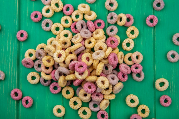 Foto gratuita vista superiore dei cereali multicolori del ciclo isolati su superficie verde