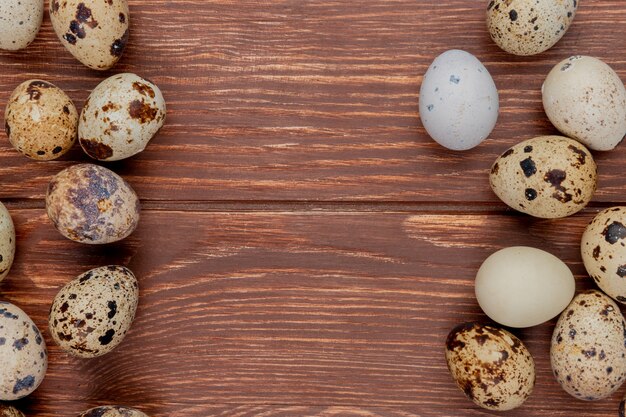 Top view of multiple fresh quail eggs isolated on a wooden background with copy space