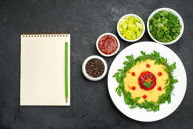 Free photo top view of mushed potato dish with greens on dark